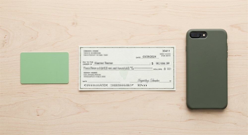 Printed payroll check and an unbranded prepaid card on a desk